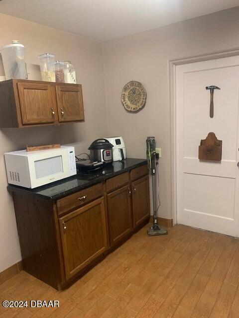 interior space with light wood-style floors and white microwave