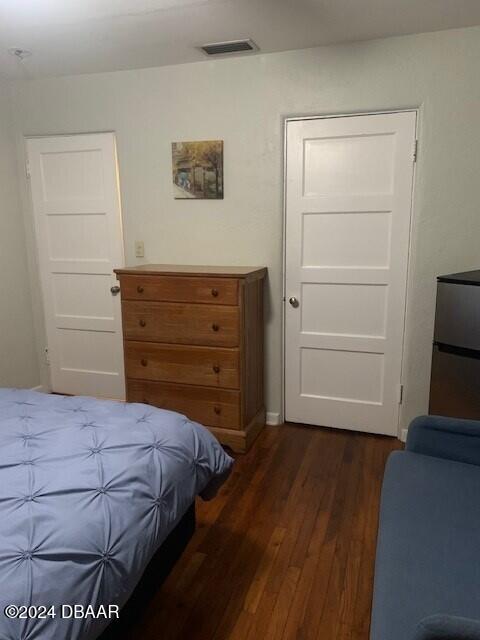 bedroom featuring dark wood-type flooring and visible vents