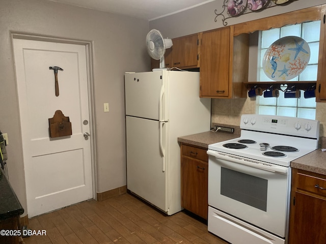 kitchen featuring white appliances, light wood-style floors, tasteful backsplash, brown cabinetry, and dark countertops