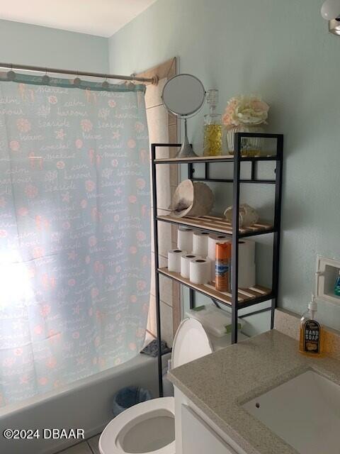 bathroom with tile patterned flooring, vanity, toilet, and shower / bath combo with shower curtain