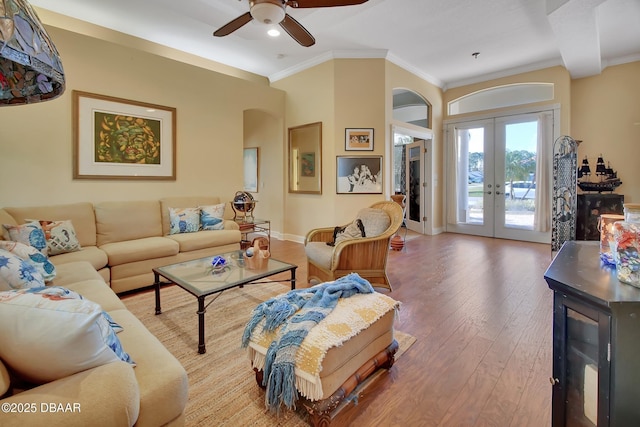 living room with french doors, ceiling fan, wood-type flooring, and crown molding