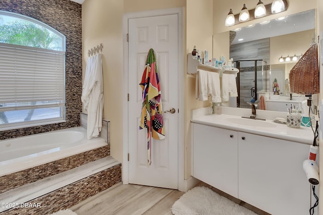 bathroom with independent shower and bath, vanity, and hardwood / wood-style flooring