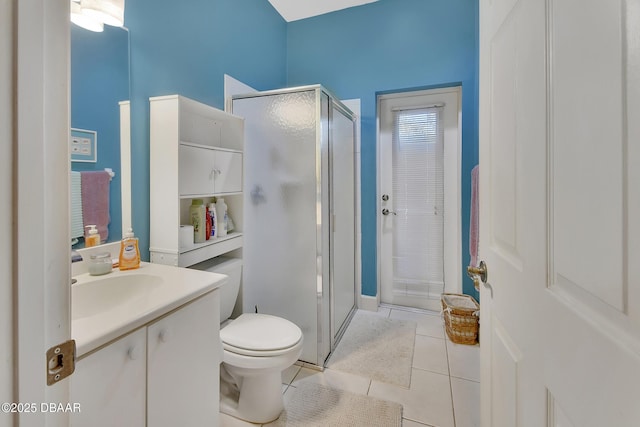 bathroom with vanity, toilet, a shower with shower door, and tile patterned flooring