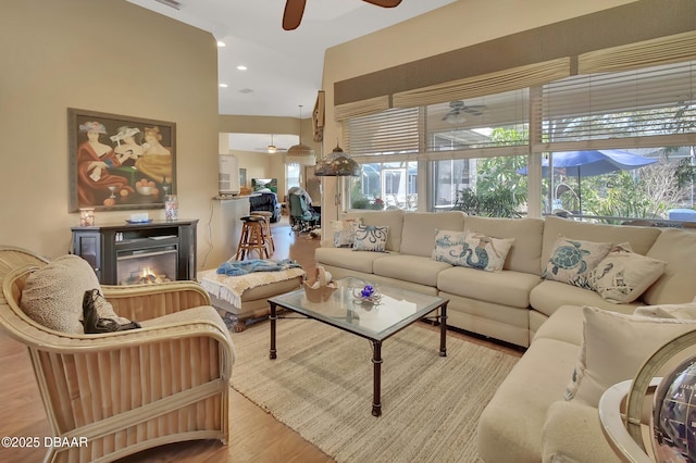 living room with ceiling fan and light hardwood / wood-style flooring