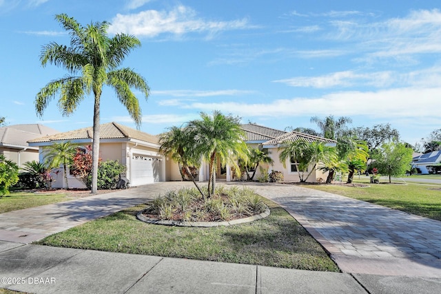 mediterranean / spanish-style house featuring a garage and a front yard