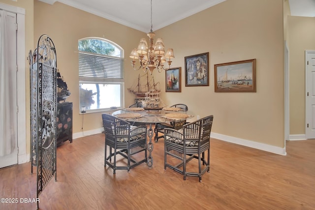 dining space with crown molding, wood-type flooring, and a chandelier