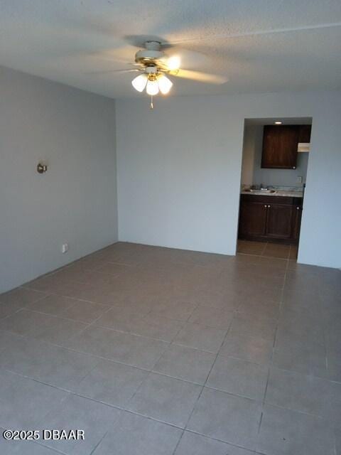 empty room featuring light tile patterned floors and ceiling fan