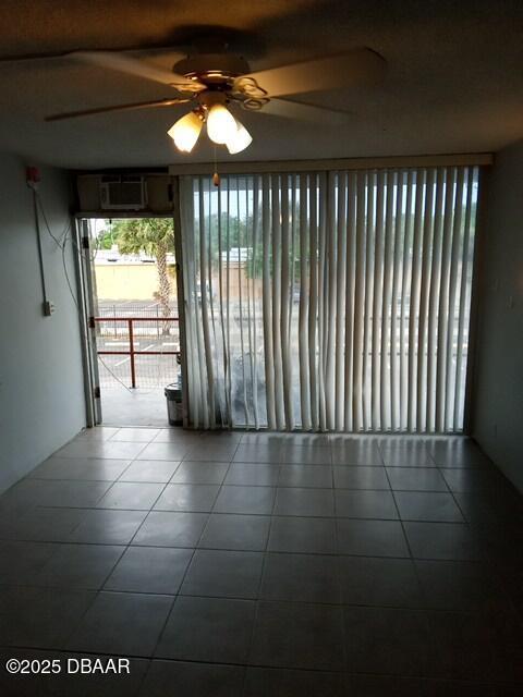 tiled empty room featuring a wall unit AC