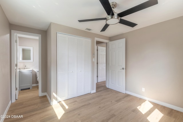 unfurnished bedroom featuring connected bathroom, a closet, ceiling fan, and light hardwood / wood-style floors