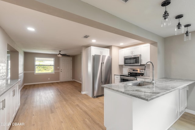 kitchen with white cabinetry, appliances with stainless steel finishes, kitchen peninsula, ceiling fan, and light hardwood / wood-style flooring