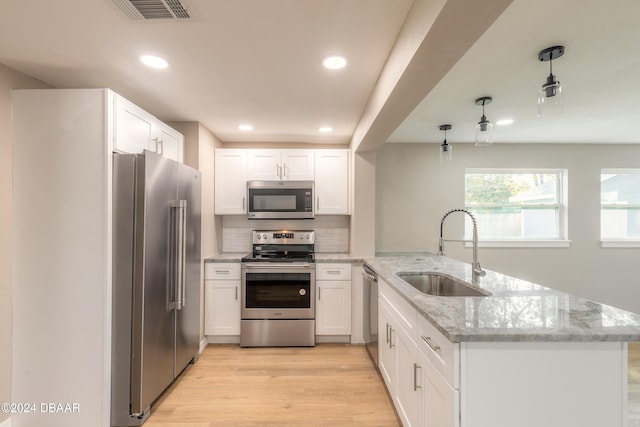 kitchen featuring kitchen peninsula, white cabinets, sink, and appliances with stainless steel finishes