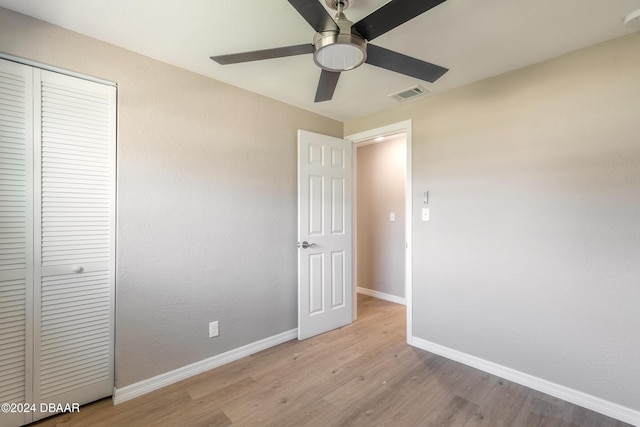 unfurnished bedroom featuring a closet, light wood-type flooring, and ceiling fan