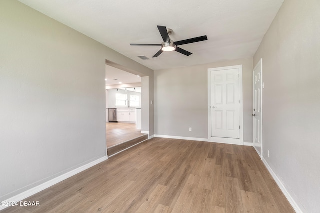 unfurnished room with sink, ceiling fan, and light hardwood / wood-style flooring