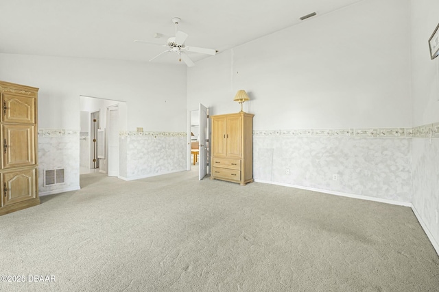 empty room with light carpet, ceiling fan, and vaulted ceiling