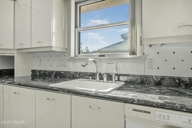 kitchen with sink, white cabinetry, dishwasher, and dark stone countertops