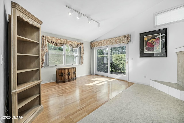 unfurnished living room featuring light hardwood / wood-style floors and lofted ceiling