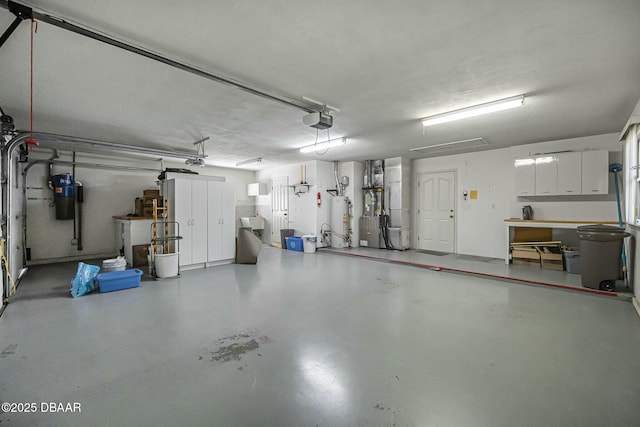 garage featuring heating unit, water heater, and a garage door opener