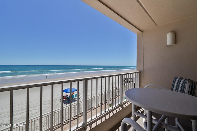 balcony featuring a water view and a view of the beach