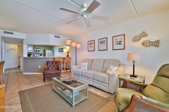 tiled living room featuring a textured ceiling and ceiling fan