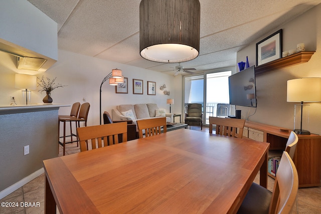 tiled dining space featuring ceiling fan