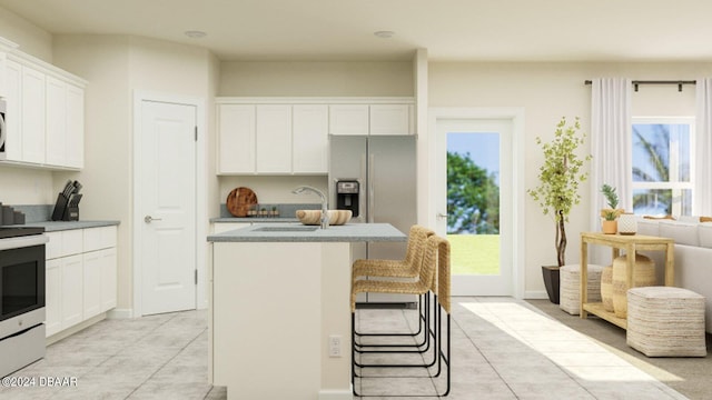 kitchen featuring white cabinets, range, stainless steel fridge, and sink