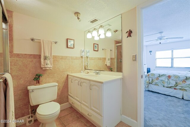 4435 S Atlantic Ave Unit 414, Ponce Inlet, FL 32127 - ensuite bathroom with toilet, a stall shower, a textured ceiling, tile patterned floors, and ceiling fan