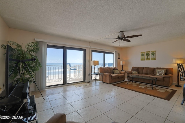 4435 S Atlantic Ave Unit 414, Ponce Inlet, FL 32127 - living area featuring light tile patterned floors, ceiling fan, and a textured ceiling
