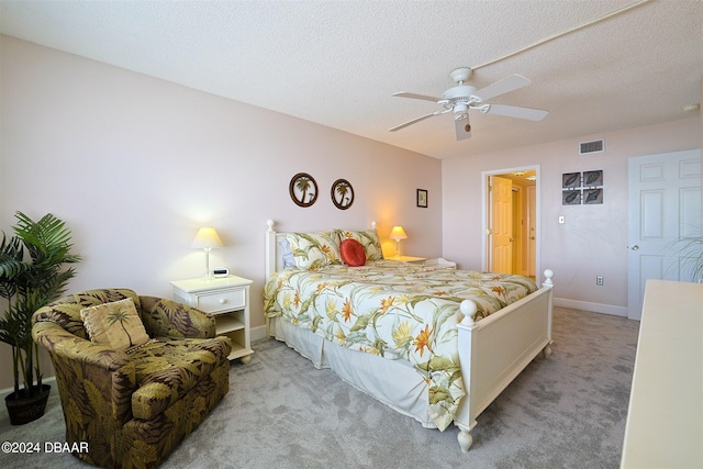 bedroom featuring a textured ceiling, light carpet, and ceiling fan