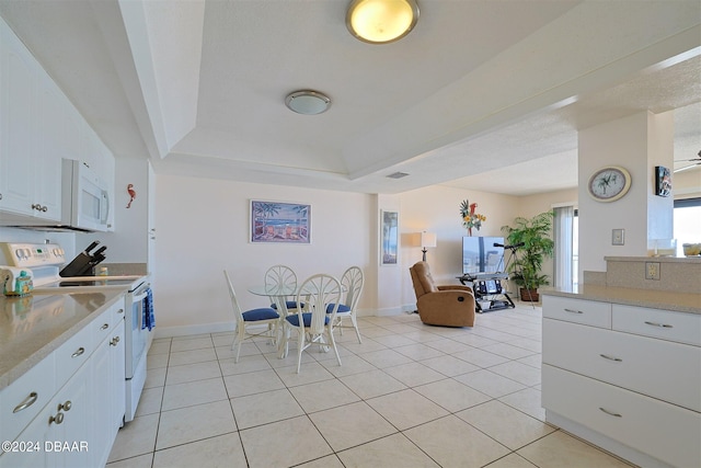 4435 S Atlantic Ave Unit 414, Ponce Inlet, FL 32127 - kitchen featuring white appliances, light countertops, white cabinets, and light tile patterned floors