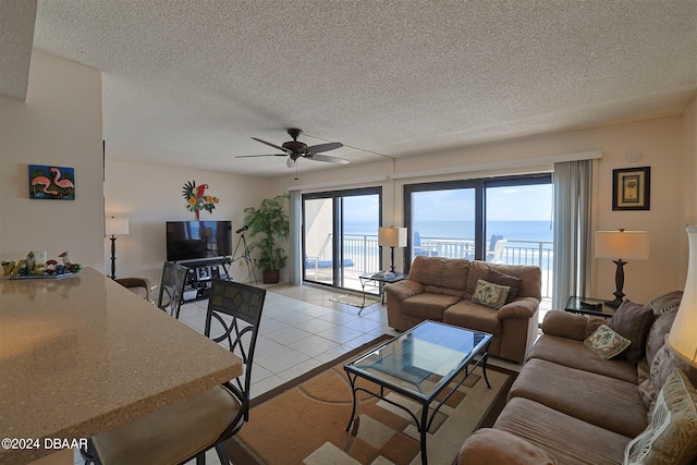 tiled living room with a textured ceiling and ceiling fan