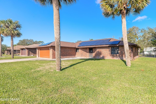 single story home with a garage, a front lawn, and solar panels