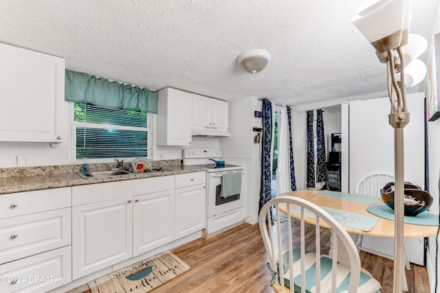 545 Cannon St, Daytona Beach, FL 32114 - kitchen with electric stove, a textured ceiling, under cabinet range hood, a sink, and light wood finished floors