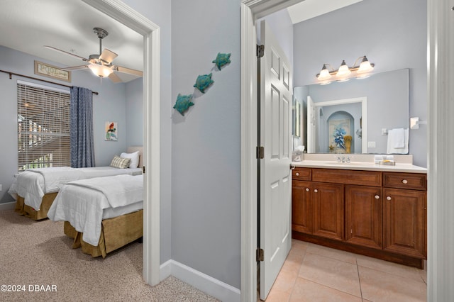 bedroom with ceiling fan, light carpet, and sink