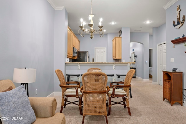 dining room featuring ornamental molding, light colored carpet, and a notable chandelier