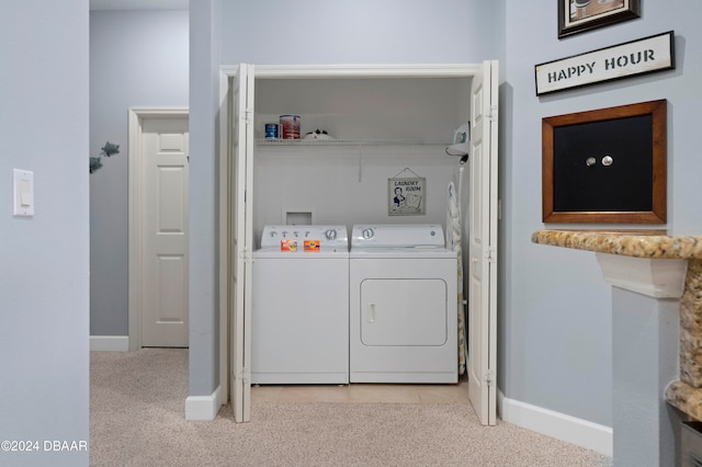 clothes washing area with washer and dryer and light carpet