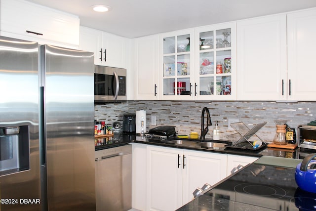 kitchen featuring white cabinets, appliances with stainless steel finishes, decorative backsplash, and sink