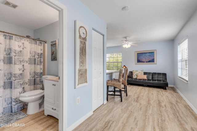 bathroom featuring hardwood / wood-style flooring, ceiling fan, toilet, and a shower with curtain