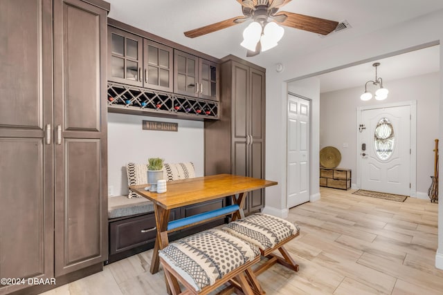 interior space with ceiling fan with notable chandelier and light hardwood / wood-style flooring