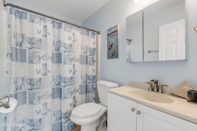 bathroom with vanity, curtained shower, and toilet