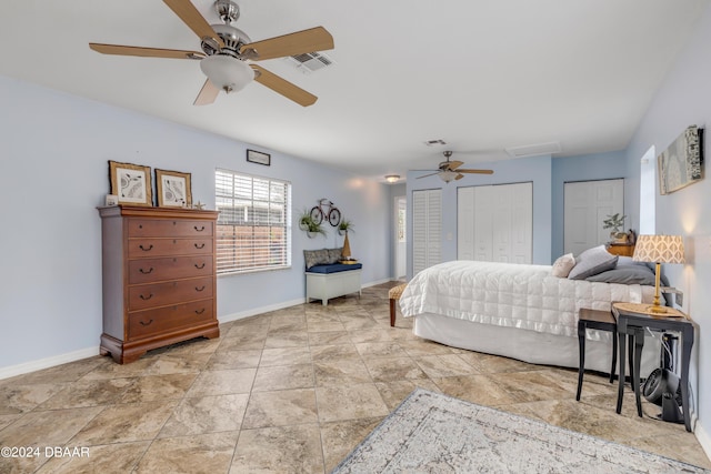 bedroom with ceiling fan and multiple closets