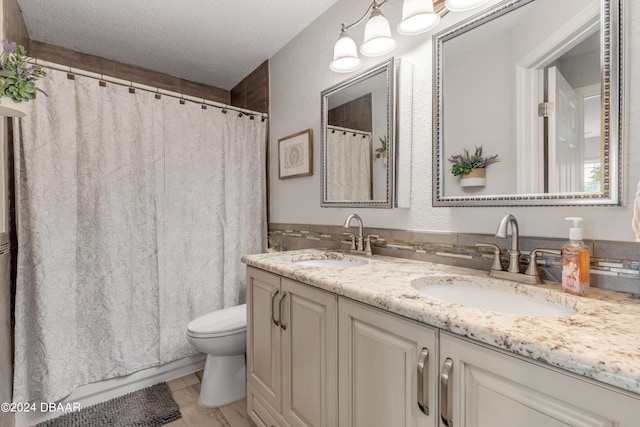 bathroom featuring vanity, toilet, and a textured ceiling