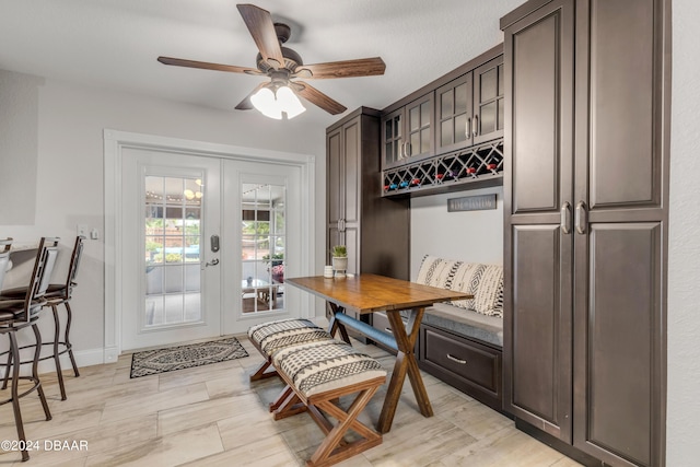 dining area with light wood-type flooring, ceiling fan, and french doors