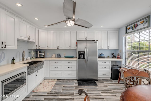 kitchen with white cabinetry, appliances with stainless steel finishes, sink, and ceiling fan