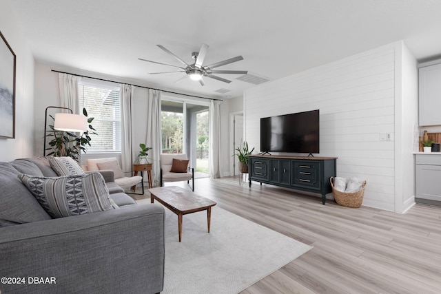 living room featuring ceiling fan and light hardwood / wood-style flooring