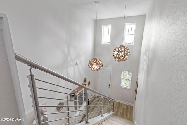 118 Pitching Wedge Dr, Daytona Beach, FL 32124 - stairway with wood finished floors, healthy amount of natural light, a towering ceiling, and a chandelier