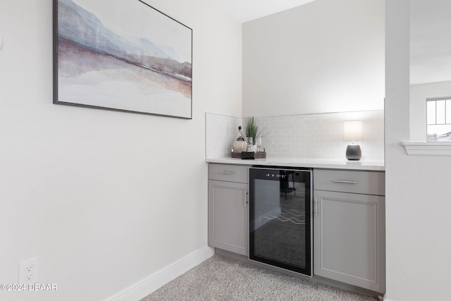 bar featuring backsplash, gray cabinets, and beverage cooler