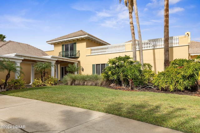 118 Pitching Wedge Dr, Daytona Beach, FL 32124 - mediterranean / spanish-style home with stucco siding, a front lawn, and a balcony