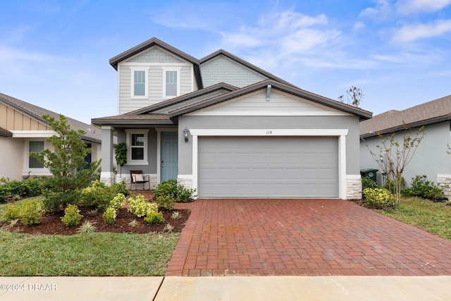 118 Pitching Wedge Dr, Daytona Beach, FL 32124 - view of front of property featuring stone siding, decorative driveway, and an attached garage