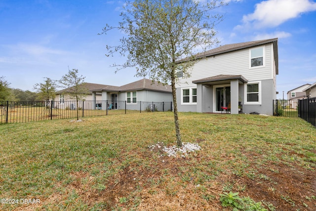 rear view of property featuring a yard