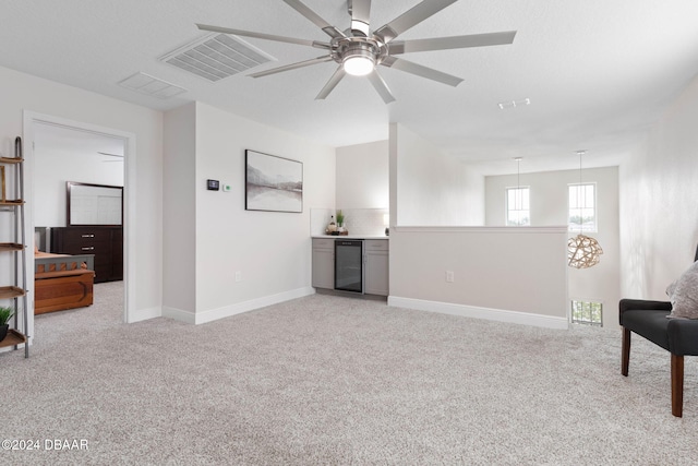 sitting room with ceiling fan, light carpet, and wine cooler